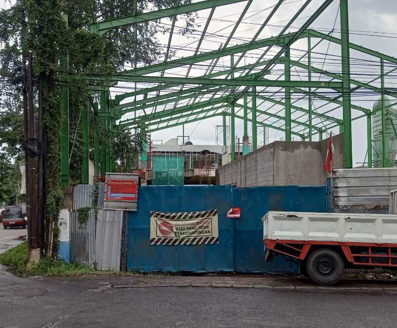 Papan penyegelan resmi Satpol PP Kota Tangerang yang terpasang di proyek bangunan Jalan Imam Bonjol Panunggangan Barat, kontras dengan aktivitas pekerja konstruksi yang masih berlangsung di latar belakang pada Jumat 16 Januari 2026.