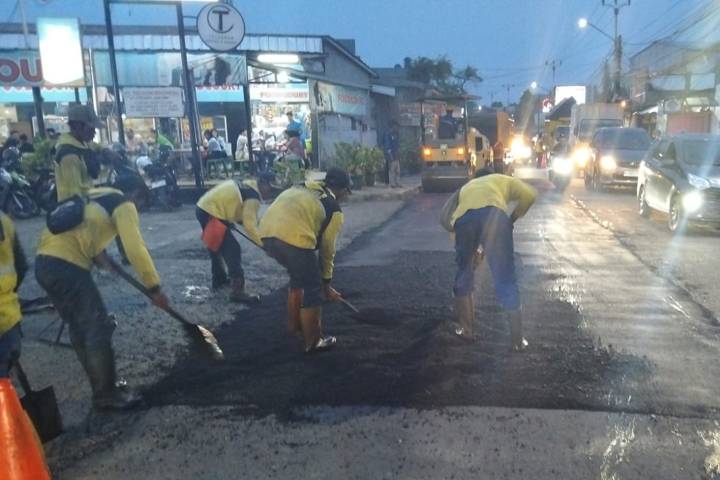 Foto udara alat berat asphalt finisher sedang menghamparkan aspal hotmix di Jalan Prabu Kian Santang yang kini nampak hitam mulus dan simetris.