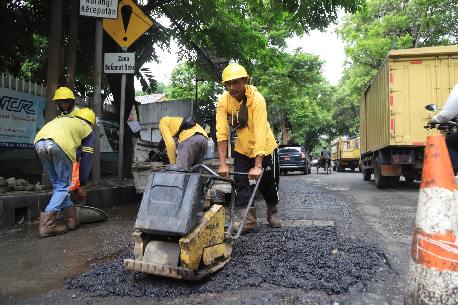 Tim personel Dinas PUPR Kota Tangerang sedang melakukan penambalan jalan berlubang menggunakan material aspal dalam program Perjaka Gesit di salah satu jalan lingkungan