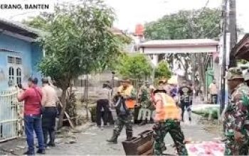 Petugas gabungan BPBD, TNI, dan Polri bersama-sama menyemprotkan air untuk membersihkan sisa lumpur banjir di jalan utama Kecamatan Periuk Tangerang
