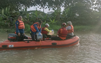 Petugas BPBD dan relawan menggunakan perahu karet menyemprotkan ekoenzim ke aliran Sungai Cisadane yang terdampak pencemaran.