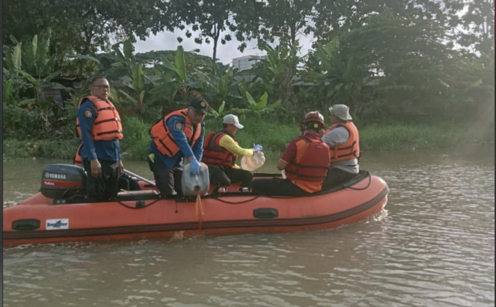 Petugas BPBD dan relawan menggunakan perahu karet menyemprotkan ekoenzim ke aliran Sungai Cisadane yang terdampak pencemaran.