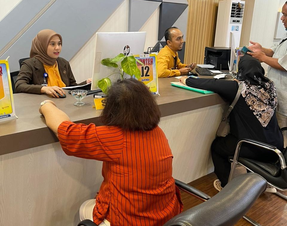 Petugas pelayanan pajak sedang melayani warga dengan ramah di loket pembayaran MPP Kota Tangerang.