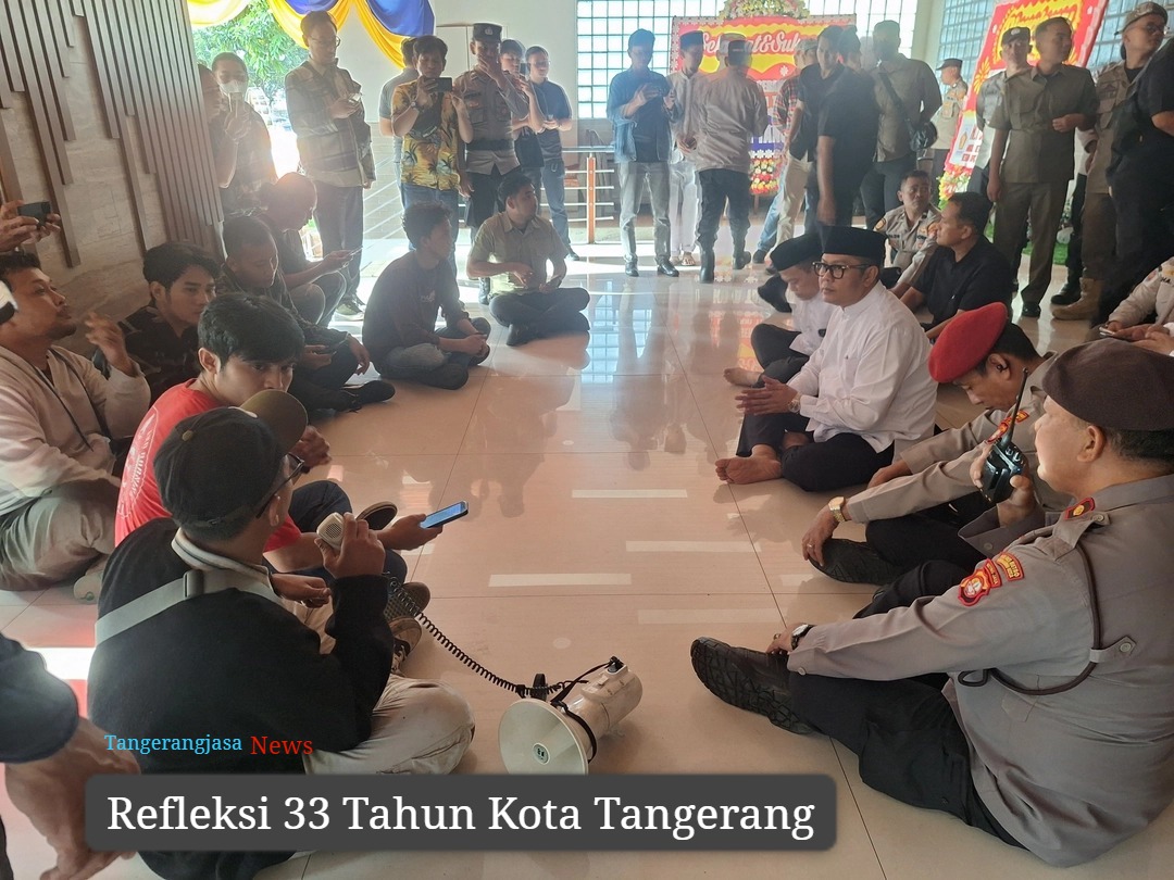Aksi mahasiswa menyampaikan aspirasi di gerbang Pusat Pemerintahan Kota Tangerang dengan latar belakang spanduk tuntutan perbaikan infrastruktur.