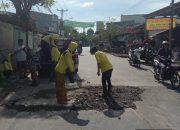 Petugas Dinas PUPR Kota Tangerang sedang melakukan penambalan jalan menggunakan material agregat di ruas Jalan Raya Kutabumi-Periuk.