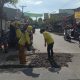 Petugas Dinas PUPR Kota Tangerang sedang melakukan penambalan jalan menggunakan material agregat di ruas Jalan Raya Kutabumi-Periuk.
