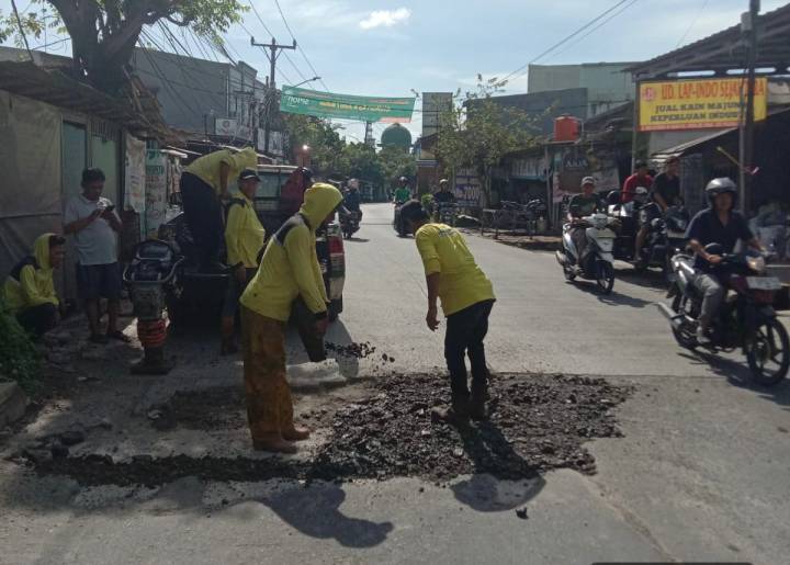 Petugas Dinas PUPR Kota Tangerang sedang melakukan penambalan jalan menggunakan material agregat di ruas Jalan Raya Kutabumi-Periuk.