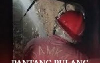 Petugas BPBD Kota Tangerang sedang berjibaku menyemprotkan air ke arah tumpukan limbah yang terbakar di kawasan Jatiuwung pada malam hari.