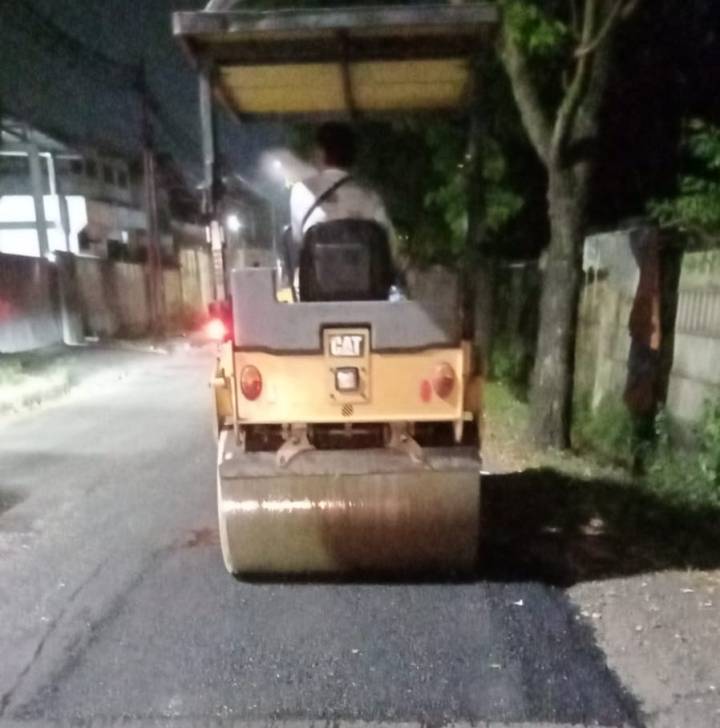 Petugas Dinas PUPR Kota Tangerang saat melakukan penambalan lubang jalan menggunakan aspal di Jalan Aria Kemuning pada malam hari.