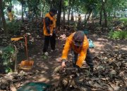 Petugas DLH Kota Tangerang sedang memasukkan sampah daun kering ke dalam kantong biopori di median jalan yang hijau sepanjang Jalan Benteng Betawi.
