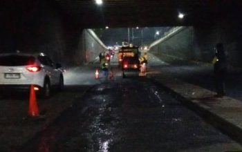 Petugas Dinas PUPR Kota Tangerang saat melakukan pengaspalan hotmix di Underpass Ciledug pada malam hari.