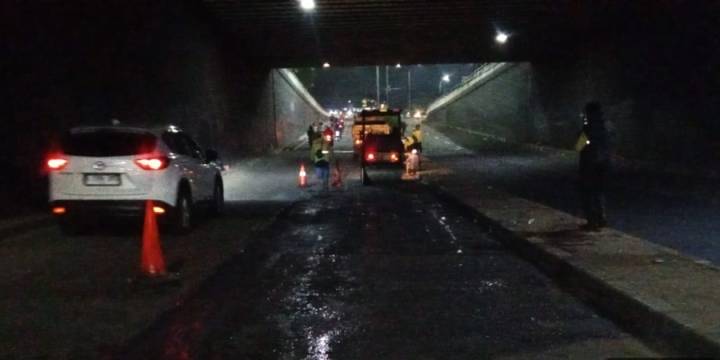 Petugas Dinas PUPR Kota Tangerang saat melakukan pengaspalan hotmix di Underpass Ciledug pada malam hari.