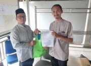 Seorang warga Kota Tangerang sedang memasukkan belanjaan ke dalam tas kain (tote bag) kanvas yang berwarna menarik di depan sebuah toko swalayan.