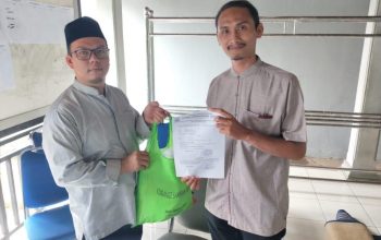 Seorang warga Kota Tangerang sedang memasukkan belanjaan ke dalam tas kain (tote bag) kanvas yang berwarna menarik di depan sebuah toko swalayan.