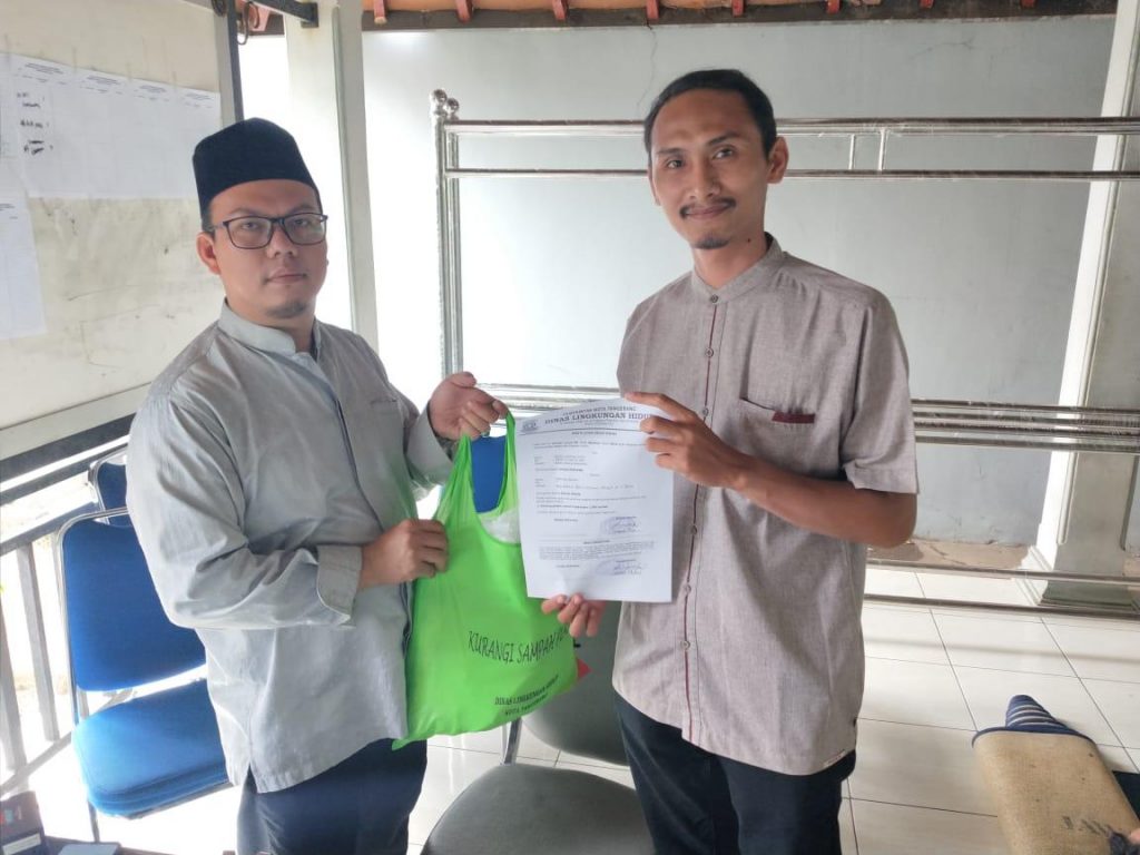 Seorang warga Kota Tangerang sedang memasukkan belanjaan ke dalam tas kain (tote bag) kanvas yang berwarna menarik di depan sebuah toko swalayan.