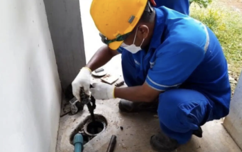 Petugas teknis Perumda Tirta Benteng sedang mengalibrasi meter air baru di pemukiman warga untuk memastikan akurasi data.