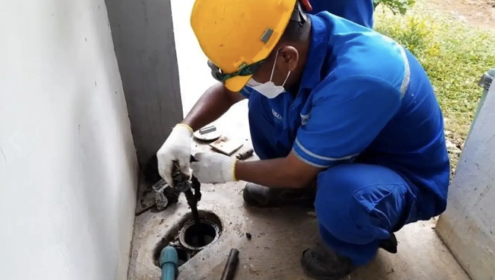 Petugas teknis Perumda Tirta Benteng sedang mengalibrasi meter air baru di pemukiman warga untuk memastikan akurasi data.