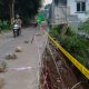 Petugas BPBD Tangsel sedang memasang garis pembatas (police line) dan rambu peringatan di sisi jalan yang longsor di Ciater.