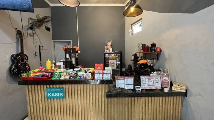 Suasana santai di Warkop Nan Kopi Ciledug dengan pelanggan yang sedang menikmati kopi manual brew di area semi-outdoor.