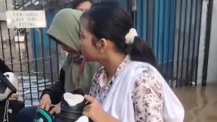 Proses evakuasi siswa sekolah dan warga menggunakan perahu karet di Kelurahan Petir, Cipondoh.