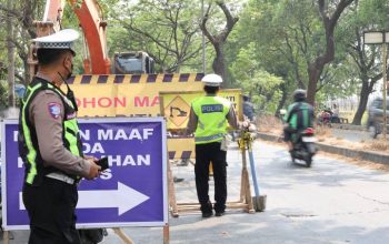 Petugas gabungan Dinas Perhubungan dan Satlantas memasang pembatas jalan untuk skema lawan arah di jalur Neglasari.