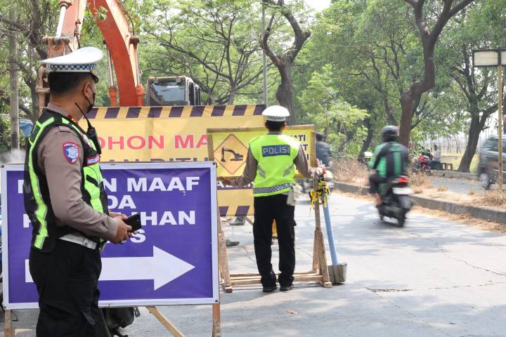 Petugas gabungan Dinas Perhubungan dan Satlantas memasang pembatas jalan untuk skema lawan arah di jalur Neglasari.
