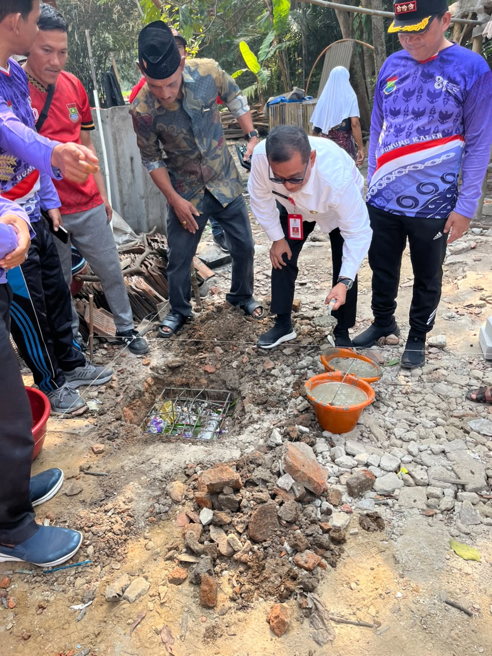 RESTORASI HUNIAN PASCA-BENCANA: Kepala DBMSDA Kabupaten Tangerang, Iwan Firmansyah (tengah), mewakili Bupati Moch. Maesyal Rasyid, memimpin prosesi peletakan batu pertama program Bedah Rumah (BSPS) untuk Ibu Laila di Kecamatan Gunung Kaler, Jumat (14/8/2026).