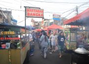 Suasana deretan gerobak pedagang kaki lima dan aktivitas warga yang memadati kawasan wisata kuliner pusaka Pasar Lama Kota Tangerang menjelang malam hari.