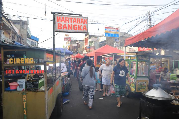 Suasana deretan gerobak pedagang kaki lima dan aktivitas warga yang memadati kawasan wisata kuliner pusaka Pasar Lama Kota Tangerang menjelang malam hari.