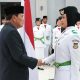 Bupati Tangerang Moch. Maesyal Rasyid saat menyematkan lencana kepemimpinan kepada perwakilan anggota Paskibraka Kabupaten Tangerang dalam upacara pengukuhan khidmat di Aula Pendopo.