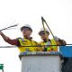 Petugas Dinas Perhubungan dan Satpol PP Kota Tangerang Selatan saat memotong dan menggulung kabel fiber optik liar yang semrawut di atas tiang utilitas Jalan Merpati, Ciputat.