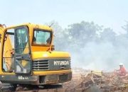 etugas BPBD menyemprotkan air ke arah gunungan sampah yang mengeluarkan asap pekat membubung tinggi.