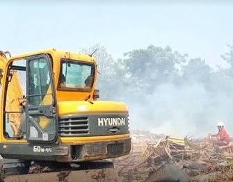 etugas BPBD menyemprotkan air ke arah gunungan sampah yang mengeluarkan asap pekat membubung tinggi.