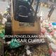 Loader tua dengan kondisi karat dan aus sedang memindahkan tumpukan sampah di area pembuangan Pasar Curug.