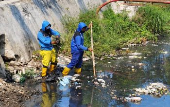 Petugas Pemkot Tangerang membersihkan tumpukan sampah di Saluran Irigasi Sipon, Cipondoh
