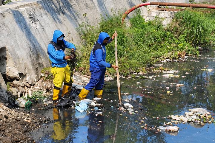 Petugas Pemkot Tangerang membersihkan tumpukan sampah di Saluran Irigasi Sipon, Cipondoh