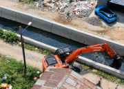 Ekskavator Dinas PUPR Kota Tangerang melakukan pengerukan sedimentasi lumpur di dasar Kali Ledug Periuk sebagai langkah mitigasi banjir.