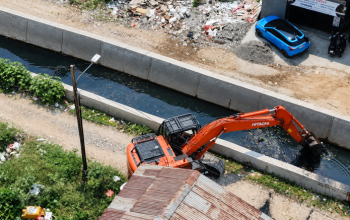 Ekskavator Dinas PUPR Kota Tangerang melakukan pengerukan sedimentasi lumpur di dasar Kali Ledug Periuk sebagai langkah mitigasi banjir.
