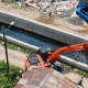 Ekskavator Dinas PUPR Kota Tangerang melakukan pengerukan sedimentasi lumpur di dasar Kali Ledug Periuk sebagai langkah mitigasi banjir.